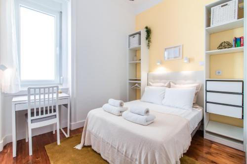 リスボンにあるGuesthouse Liberdade - 7 Bedroom Apartmentの小さなベッドルーム(タオル付きのベッド1台付)