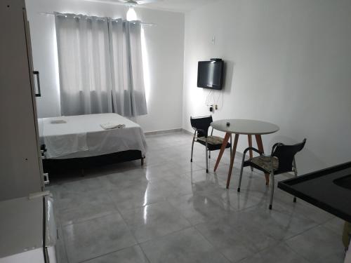 Ubá的住宿－Flat 302，配有一张床和一张桌子及椅子的房间