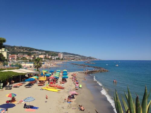 a beach filled with lots of beach chairs and umbrellas at Hotel Ideal in Arma di Taggia
