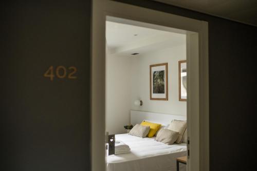 a bedroom with two beds with white sheets at HOTEL ORDIZIA in Villafranca de Ordizia