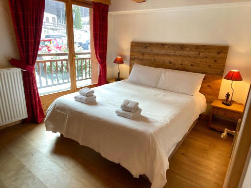 een slaapkamer met een bed met twee handdoeken erop bij Chalet Roseau in Megève