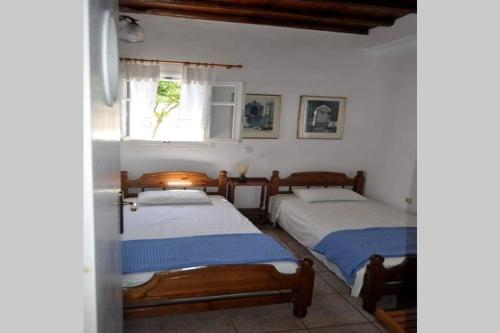a bedroom with two beds and a window at Pigeon House Ornos Beach in Mikonos