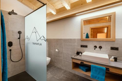La salle de bains est pourvue d'un lavabo et d'un miroir. dans l'établissement Alp Apart, à Oetz