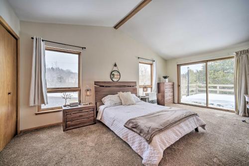 Un dormitorio con una cama y una ventana grande. en Stylish Mountain Escape with Hot Tub, 3 Miles to Ski, en Windham