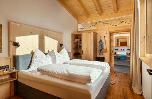 - une chambre avec un grand lit blanc dans l'établissement Alp Apart, à Oetz