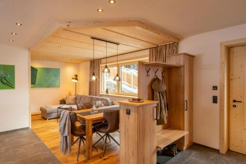 a kitchen and living room with a table and a couch at Alp Apart in Oetz