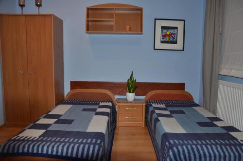 une chambre avec deux lits et une plante en pot dans l'établissement Marta, à Okuninka