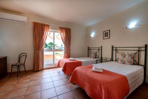 a hotel room with two beds and a window at Villas Pinhal da Falésia in Albufeira
