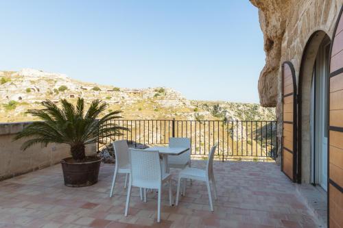 eine Terrasse mit Tisch und Stühlen auf einem Balkon in der Unterkunft La Corte Dei Pastori Luxury in Matera