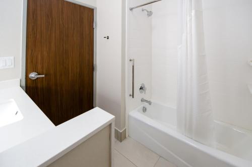 a bathroom with a sink and a tub and a shower at Holiday Inn Express & Suites Taylor by IHG in Taylor