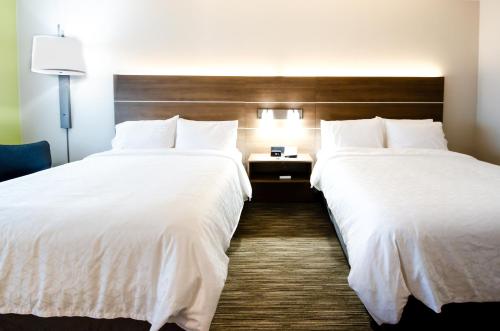two beds in a hotel room with white sheets at Holiday Inn Express & Suites Taylor by IHG in Taylor