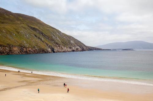 a group of people walking on a beach at Mountain View Holiday Home by Trident Holiday Homes in Louisburgh