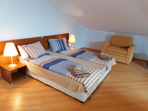 a bedroom with two beds and a chair at Studio Villa Park 408 in Borovets