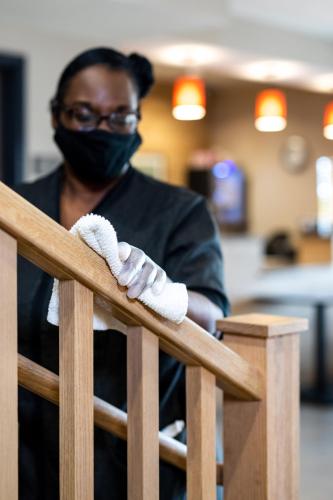 a woman wearing a mask and gloves on a railing at Country Inn & Suites by Radisson, Washington Dulles International Airport, VA in Sterling