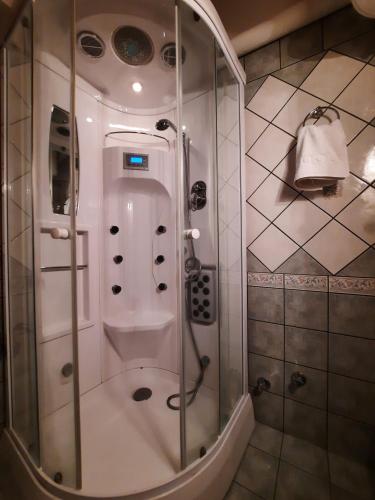 a shower with a glass door in a bathroom at La Petri Studios with Fireplace & View in Metsovo