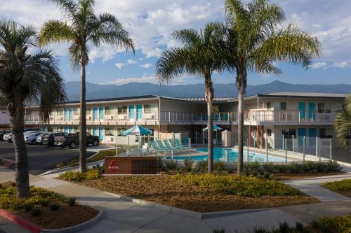 a view of a hotel with palm trees and a pool at Motel 6-Santa Barbara, CA - Beach in Santa Barbara