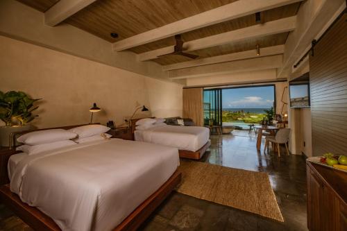 a bedroom with two beds and a view of the ocean at Atelier Playa Mujeres- Adults Only - All Inclusive Resort in Cancún
