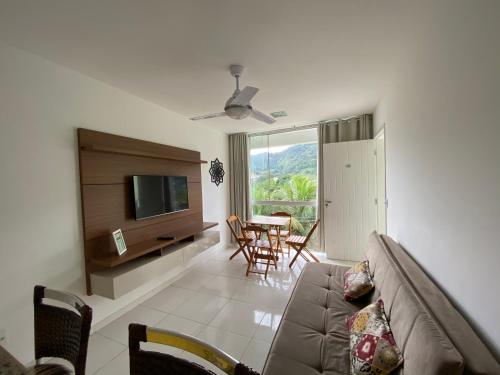 een woonkamer met een bank en een televisie bij Eco Ribeira in Angra dos Reis