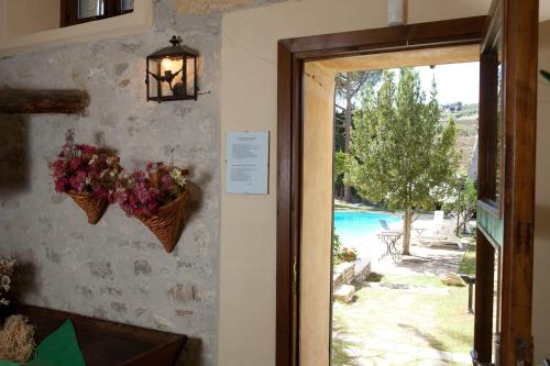 a door to a room with a view of a pool at Agriturismo Baglio Fontana in Buseto Palizzolo