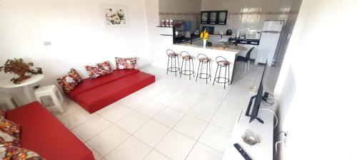 a living room with a red couch and a kitchen at Ap05-A 50 Metros da Praia Flats Mobiliados para 6 Pessoas in Paulista