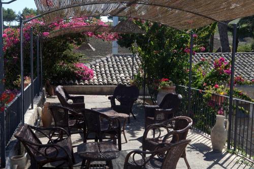 a group of chairs and tables on a patio with flowers at Agriturismo Baglio Fontana in Buseto Palizzolo