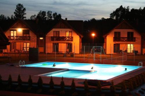 a large swimming pool in front of some houses at Apartament Łeba in Żarnowska