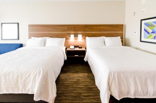 two beds in a hotel room with white sheets at Holiday Inn Express & Suites Taylor by IHG in Taylor