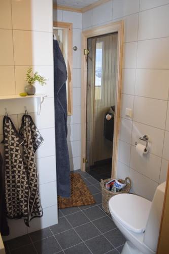 a bathroom with a toilet and a door to a shower at Ferienhaus Fjellblikken in Sinnes