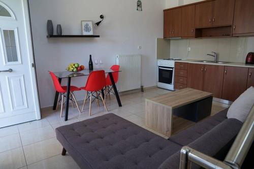 kuchnia ze stołem i czerwonymi krzesłami w pokoju w obiekcie Aphrodite's apartment w mieście Galatás