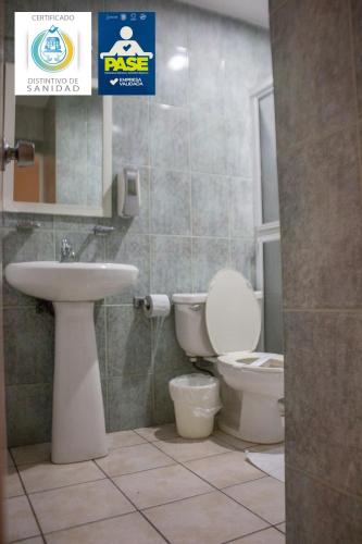 a bathroom with a toilet and a sink at Hotel Maioris El Diez Culiacan in Culiacán