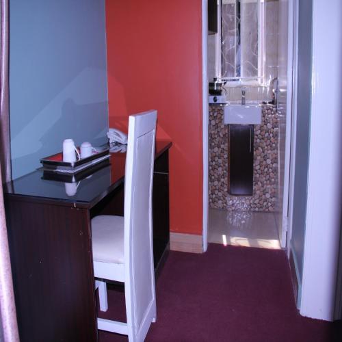 a bathroom with a desk with a sink and a shower at Bethel Resort & Hotels in Gulu