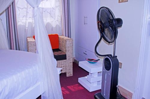 a bedroom with a bed and a fan in a room at Bethel Resort & Hotels in Gulu