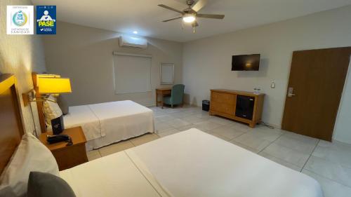 a hotel room with a bed and a tv at Hotel Maioris Navolato in San Pedro