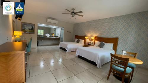 a hotel room with two beds and a table at Hotel Maioris Navolato in San Pedro