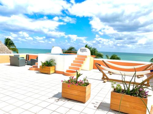 a patio with a chair and flowers and the ocean at Seaside Villas in Caye Caulker