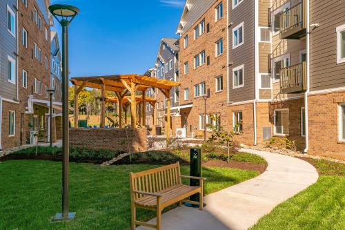 a park bench next to a building with a gazebo at WaterWalk Extended Stay by Wyndham Charlotte - Arrowood in Charlotte
