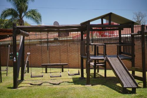 a wooden playground with a slide and a bench at Cabañas La Aldea in Villa Carlos Paz