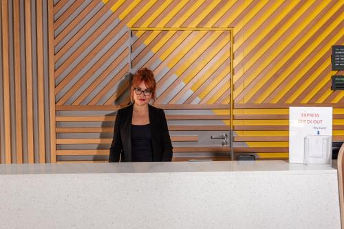 a woman standing behind a counter in a bathroom at Holiday Inn Dover by IHG in Dover