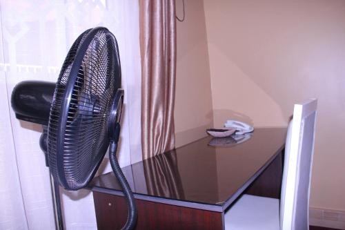 a black desk with a glass table with a phone at Bethel Resort & Hotels in Gulu