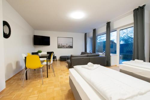 a living room with two beds and a table at RAJ Living - 1 , 3 and 4 Room Apartments - 20 min Messe DUS & Airport DUS in Meerbusch