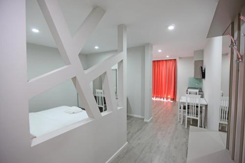 a white room with a bed and a kitchen at Hotel Star in Sarandë