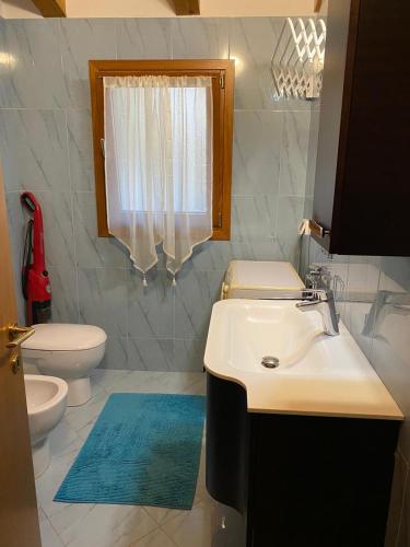 a bathroom with a sink and a toilet and a window at Cozy home in Pertegada