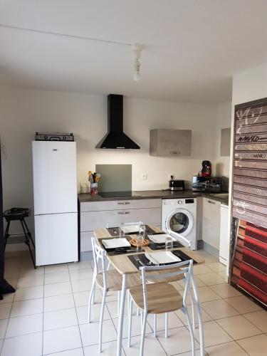 une cuisine avec une table et des chaises dans une cuisine dans l'établissement Maison cosy au bord de la mer, au Barcarès