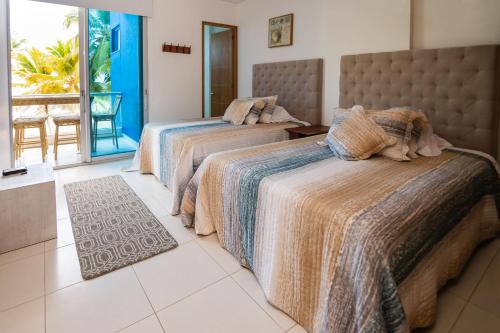 two beds in a room with a balcony at Hermoso Apartamento Frente al Mar 2 Habitaciones PAZ122 in Coveñitas