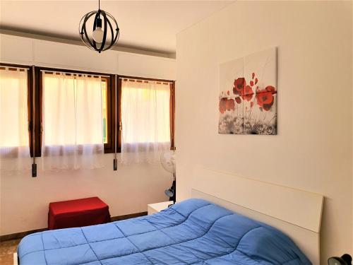 a bedroom with a blue bed and a painting on the wall at Centre Home in Rapallo