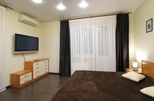 Habitación de hotel con cama y TV en Apartment on Mordovskaya 22 en Saransk
