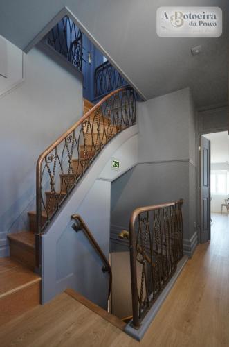 a staircase in a house with blue walls and wooden floors at A Botoeira da Praça guest house in Viana do Castelo