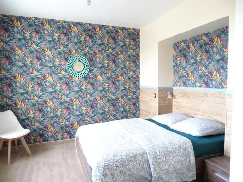 a bedroom with a bed and a floral wallpaper at Le Panorama - Vue mer in Criel-sur-Mer