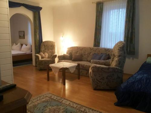 a living room with a couch and two chairs at Urlaub am Ruthnerberg in Schwarzenau