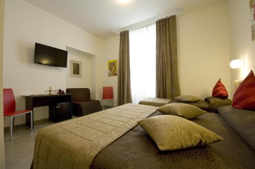 een slaapkamer met 2 bedden, een bureau en een televisie bij Ara Pacis Inn in Rome